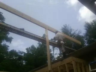 Carpenter setting a ridge beam over a new addition frame — Ice Dam Removal by Roofing Brothers in Glenn