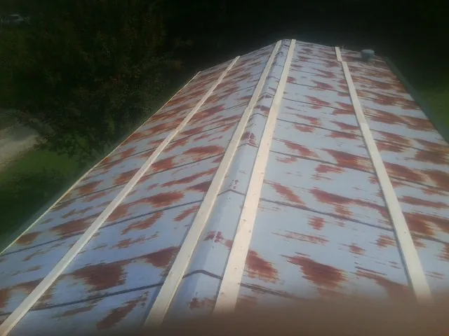 Rusted metal roof panels with new wood purlins before replacement — Storm Damage Roof Repair in Glenn by Roofing Brothers