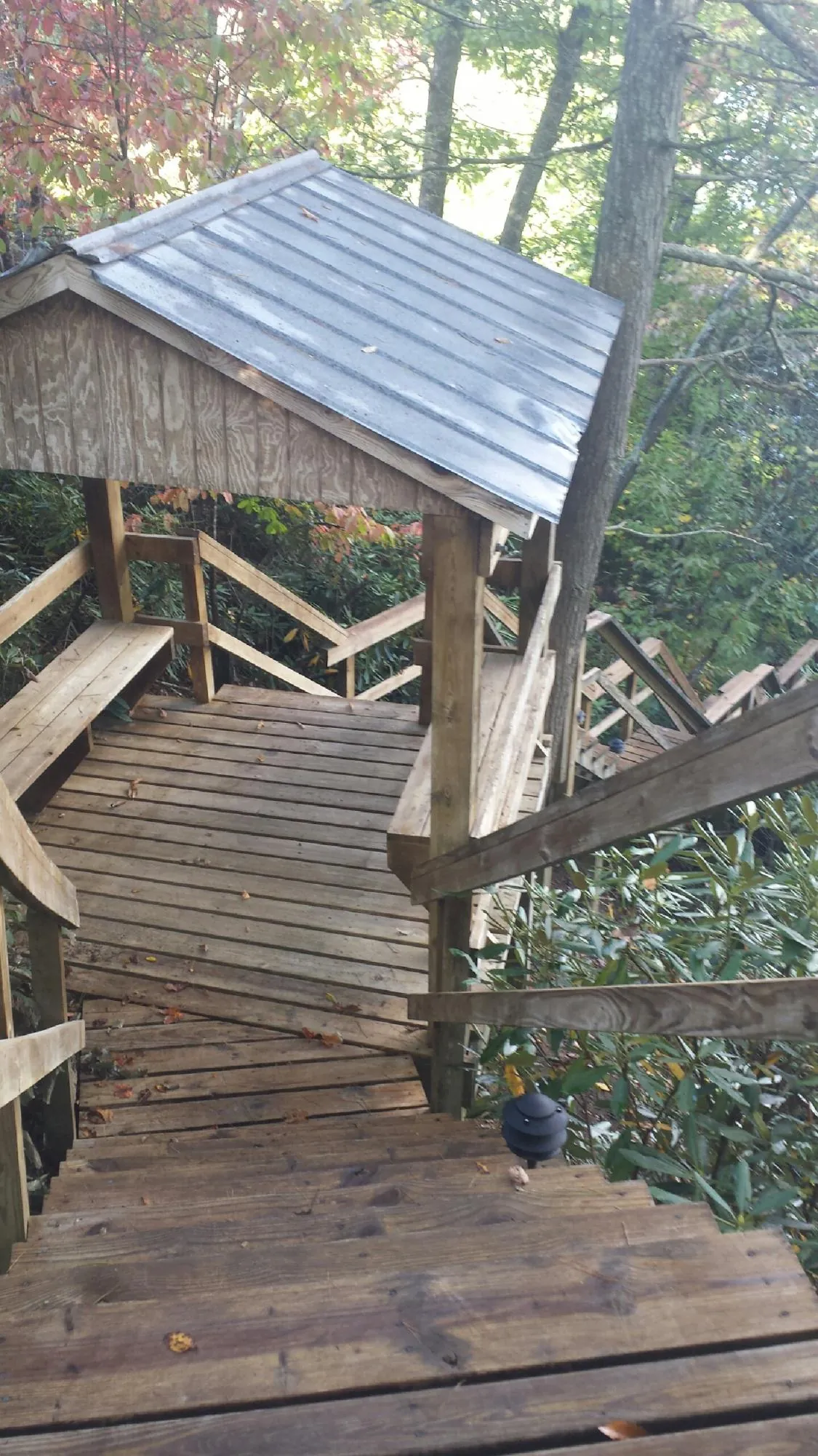 Metal roofed shelter over wooden steps on a wooded walkway — Skylight Repair & Installation work by our crew in Glenn
